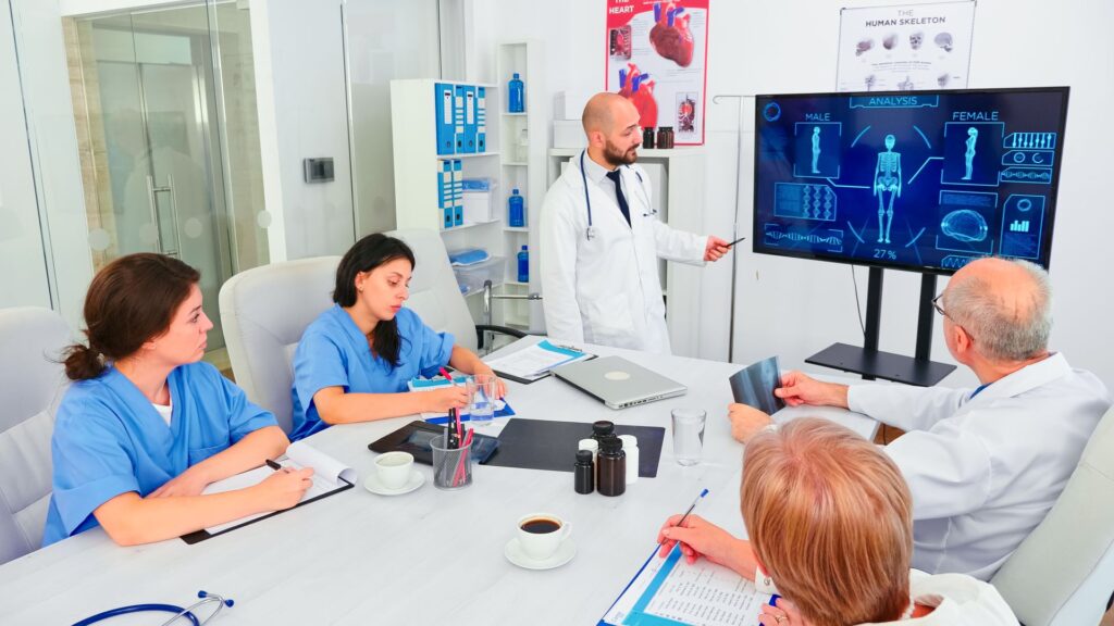 mature-medical-physician-explaining-treatment-nurses-during-healthcare-seminar-pointing-digital-monitor-clinic-herapist-discussing-with-colleagues-about-disease-medicine-professional92
